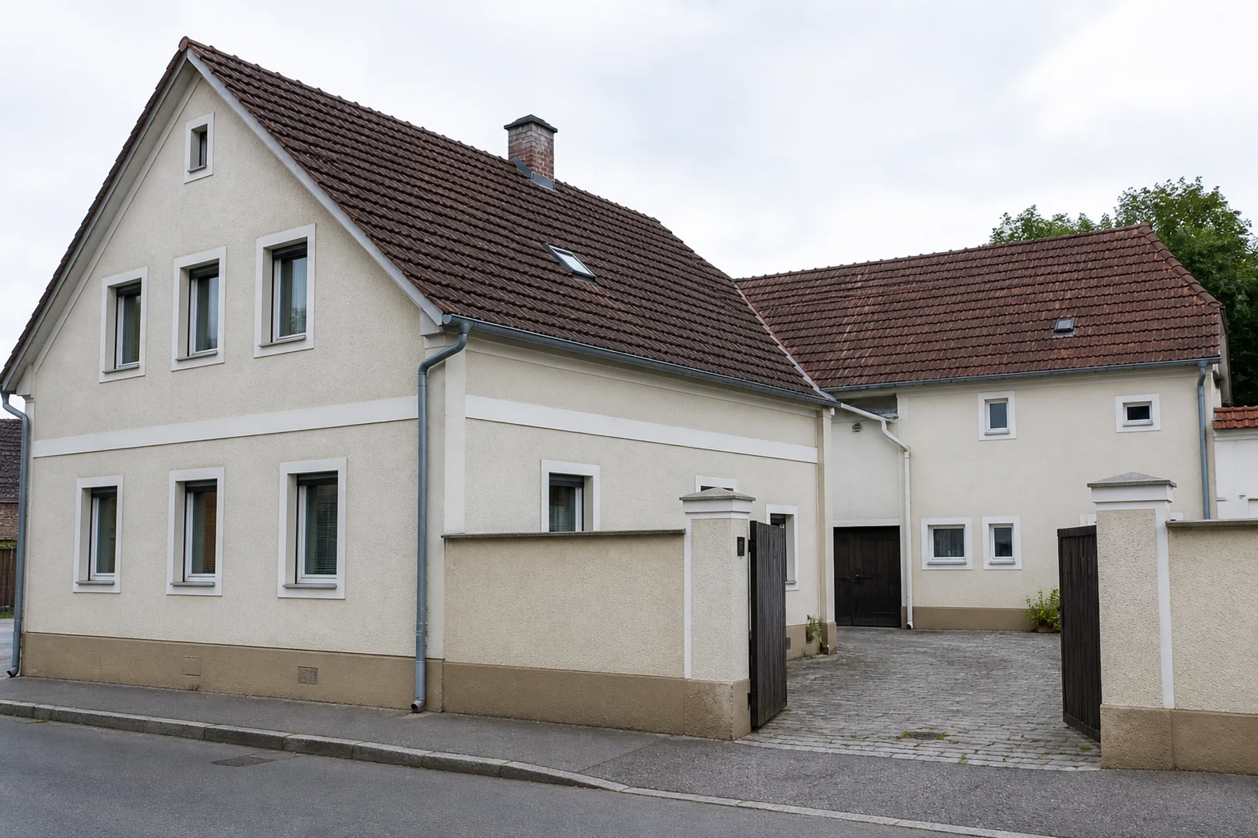 Österreichische Bestandsliegenschaft mit Hauptgebäude, Seitenflügel und Hofzugang